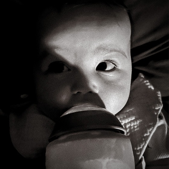 Photography and Graphic Design by JSA graphic Design featuring infant bottle-feeding in black and white.